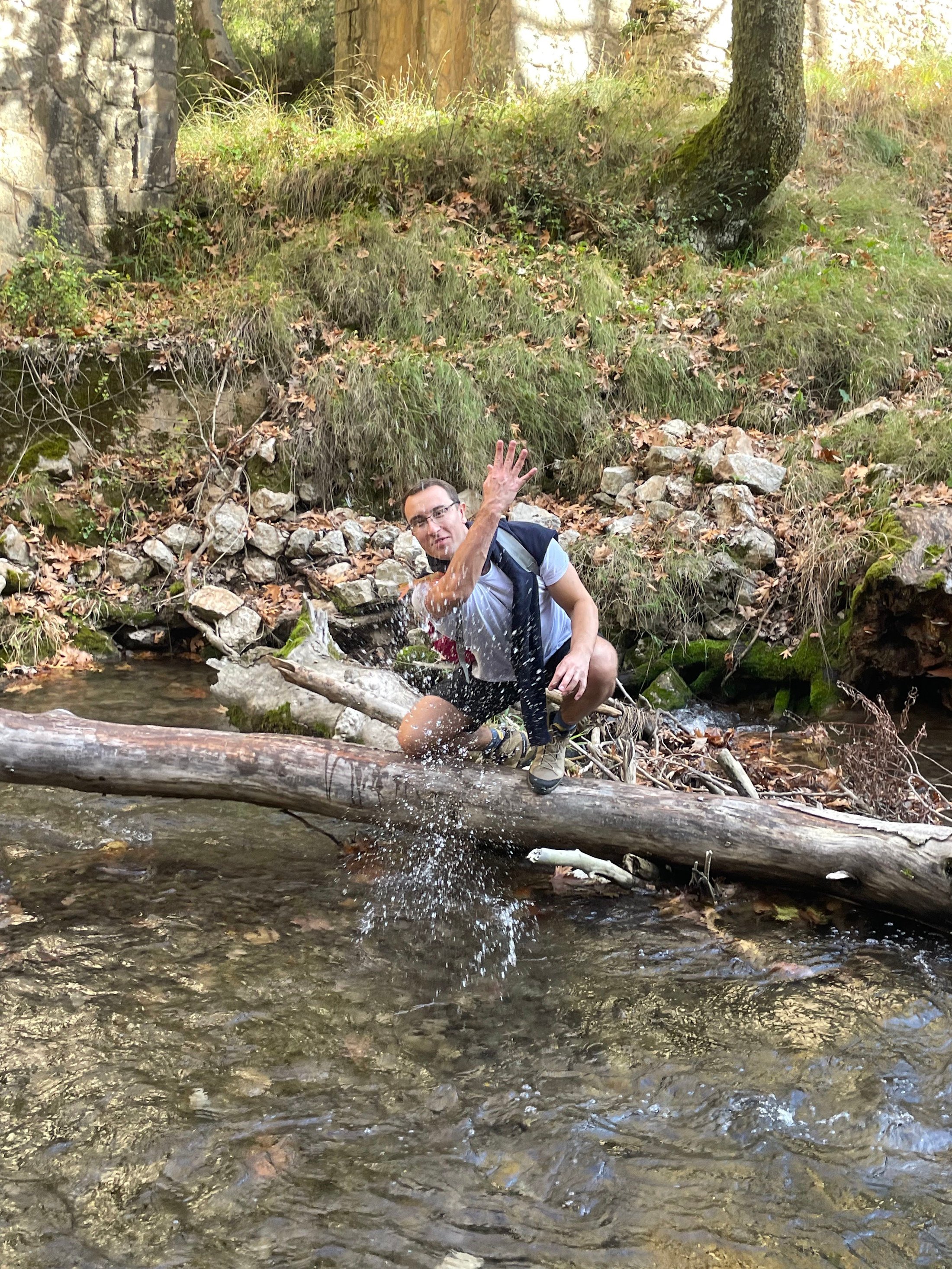 Alexander Kyriakou sits over a river and throws some water to the photographer in the autumn of 2025