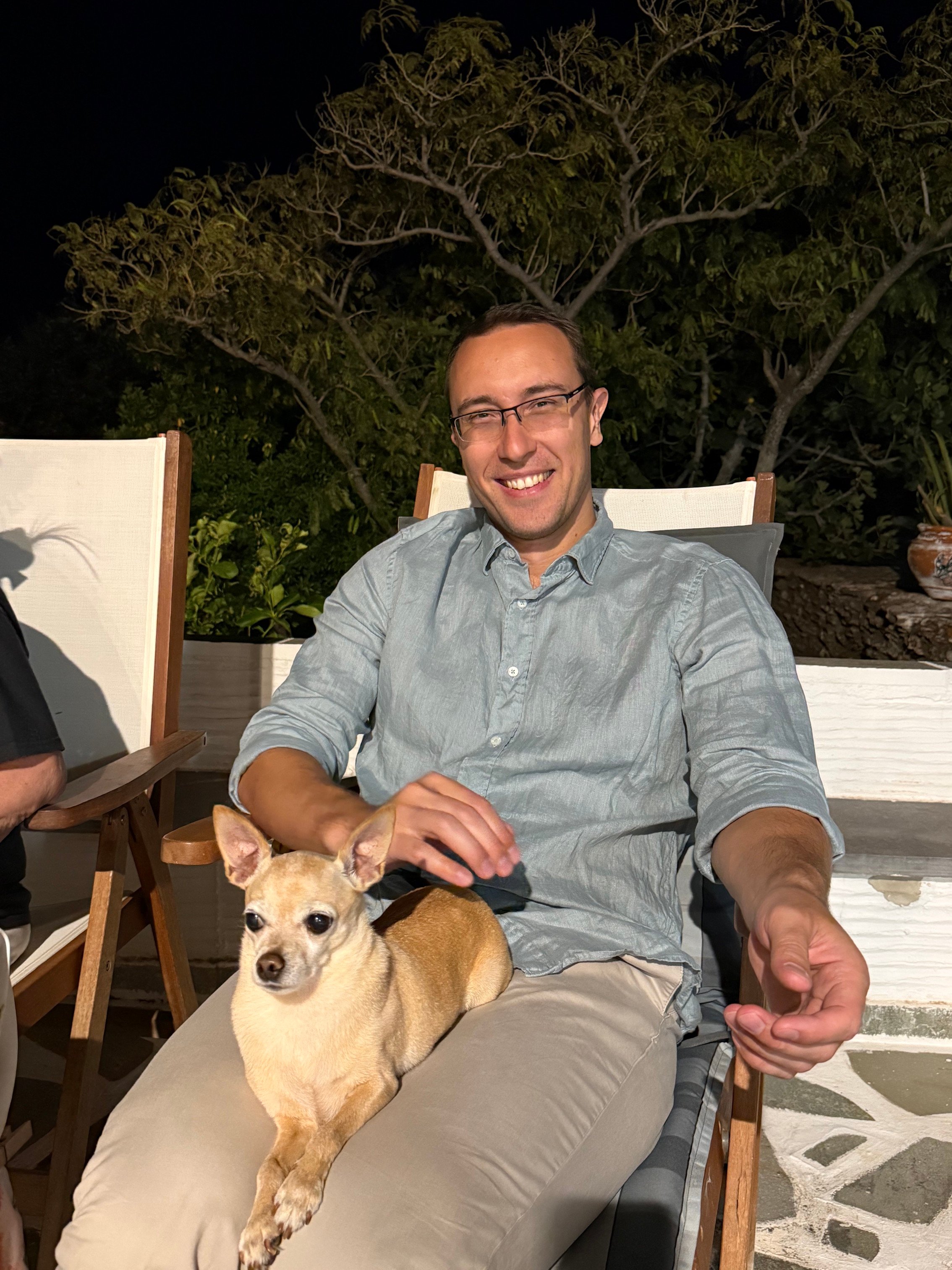 Alexander Kyriakou with a little dog on his laps in the Summer of 2026