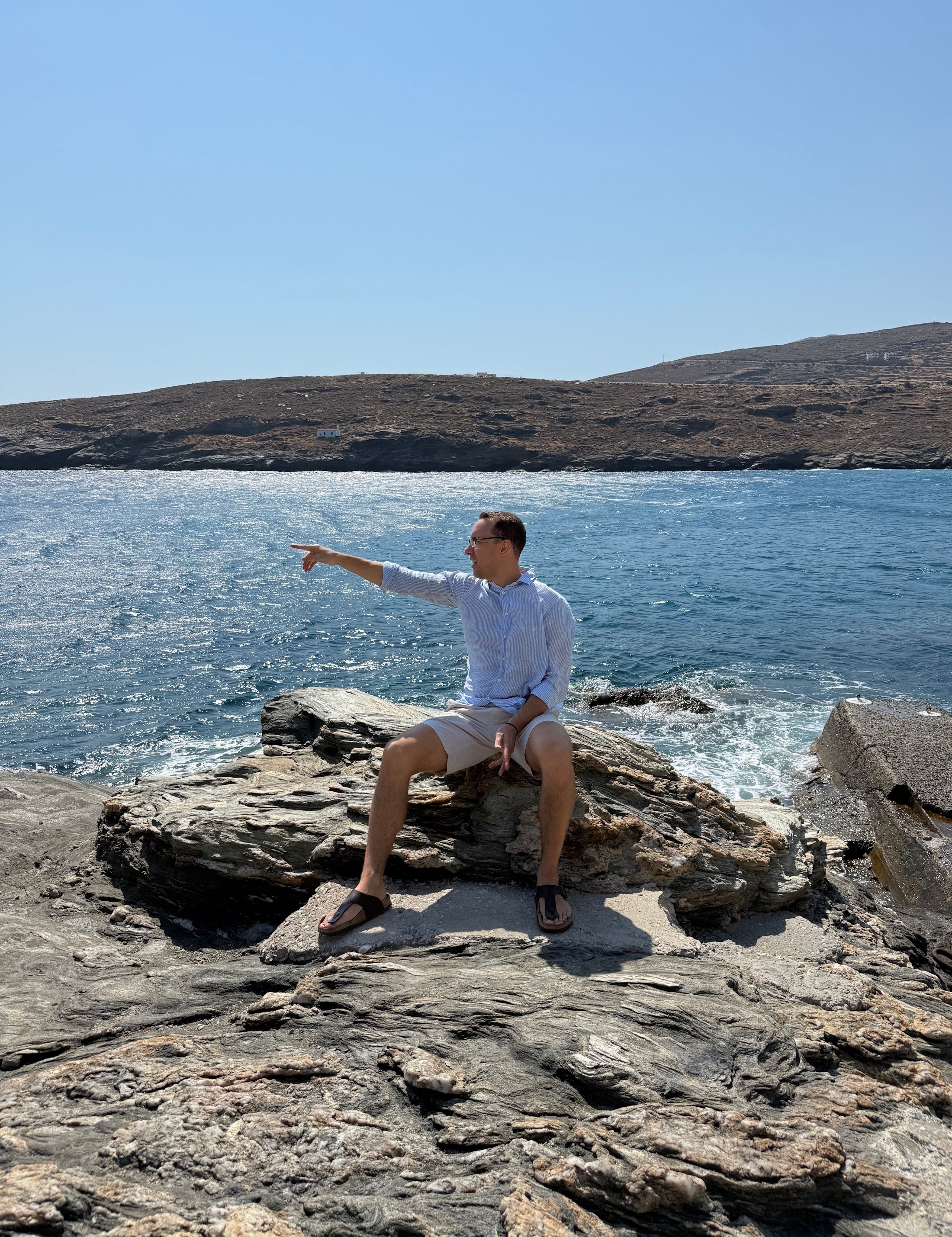 Alexander Kyriakou points to the right nearby a sea at Andros, summer of 2026